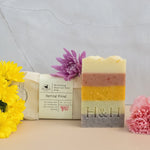 Bar of soap with flowers and packaging on a textured surface