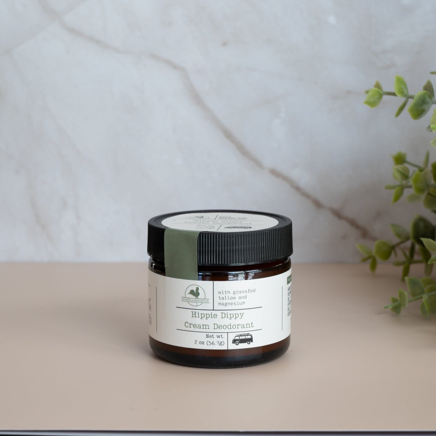 Jar of cream with a label on a light surface next to a plant